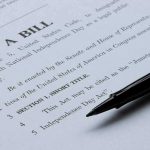 Elites Feast, Deficit Balloons — $95B Push Bill document with pen on paper