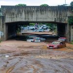 Flooded underpass with stranded cars in muddy water
