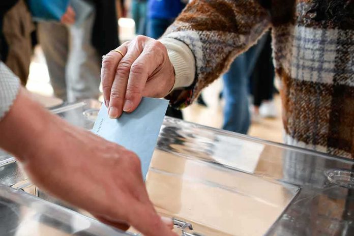 Hand inserting ballot into transparent box