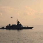 Warship cruising at sea during sunset