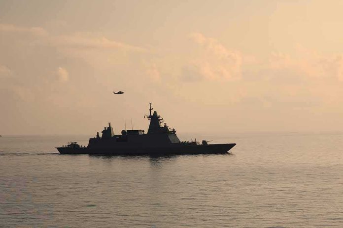 Warship cruising at sea during sunset