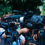 Malibu Shock: Cage-Linked Home Craters TV news cameras crowding together at an outdoor event