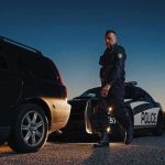 False Abuse Call Triggers CPS Blitz Police officer standing near patrol car during twilight traffic stop