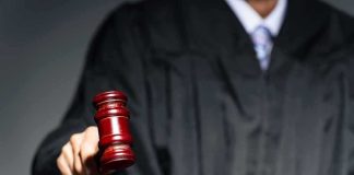 Judge with gavel striking sound block