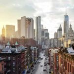 Tenant Victory Today, Crumbling Buildings Tomorrow City street leading to a skyline of modern and historic skyscrapers at sunset