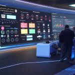 Election Whiplash Ahead – Traders Salivate cybersecurity operations room with large data dashboards and people discussing