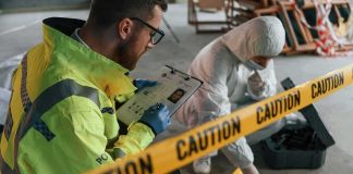 Police officer and forensic investigator at a crime scene behind caution tape