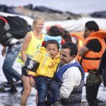 7.8 Earthquake Hits Philippines — Tsunami Warnings Across the Region man carries child wearing life jacket at shoreline