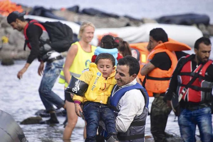 shutterstock_320039453 man carries child wearing life jacket at shoreline