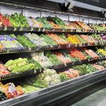 Tainted Lettuce Panic Sweeps 27 States Grocery store produce aisle with stacked fresh vegetables