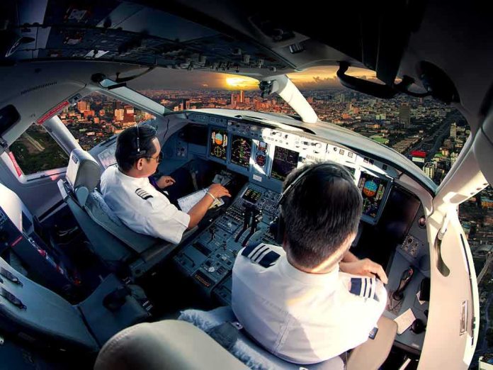 Pilots in an airplane cockpit during city approach at sunset