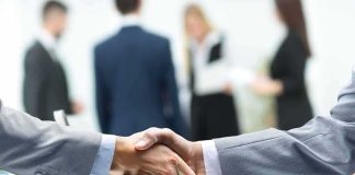 AI Crisis Hotline? Beijing Didn’t Plan This Businessmen handshake over a glass desk
