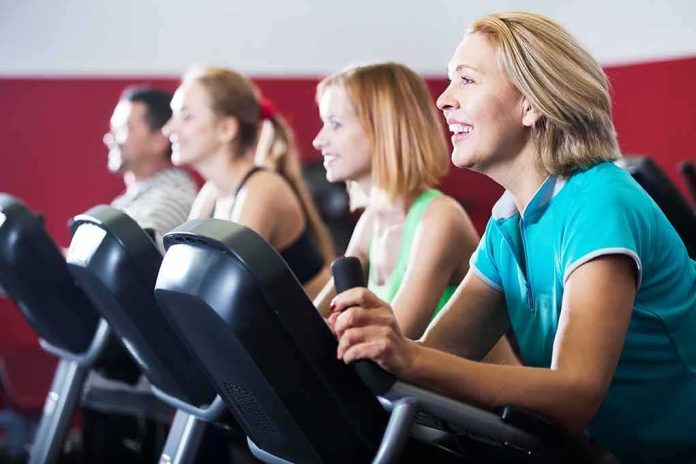 shutterstock_532327636 group of people cycling on exercise bikes at a gym