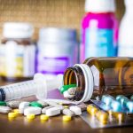 Washington’s $50 GLP-1 Program Could Cost More Than You Think Medicine pills and syringe on table with brown bottle