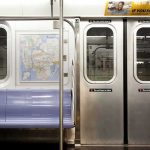 Subway car interior with stainless doors and empty blue bench