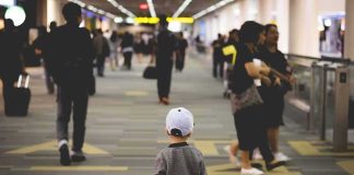 child walking through a busy airport corridor