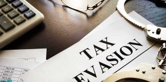 Handcuffs and calculator on tax evasion document