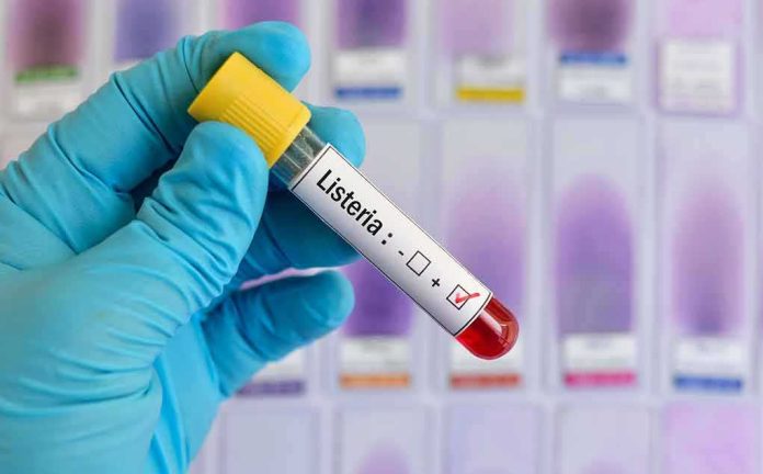 shutterstock_1041103306 Gloved hand holding a blood sample tube labeled for listeria test