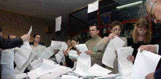 People counting ballots at a table
