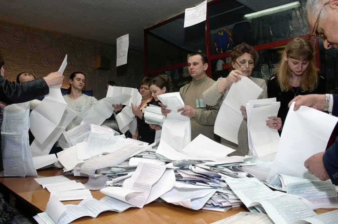 shutterstock_1208093 People counting ballots at a table