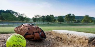 Softball Stands ERUPT – Grandpa Down, Bonds Set Softball and glove near a base on a dirt field