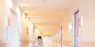 Hospital corridor with doors and medical cart