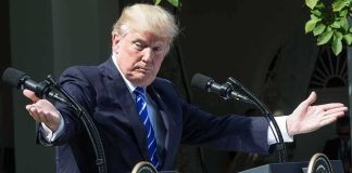 Donald Trump speaking at dual podiums with arms outstretched