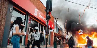 France Cracks Down: Gatherings Banned Street protest with fire and smoke outside a bank
