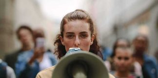 Shocking 82% Stat – Context Changes Everything woman with megaphone leading a street protest