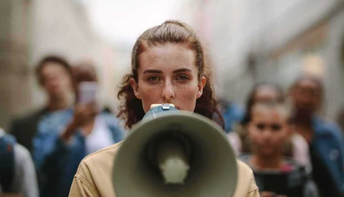 woman with megaphone leading a street protest