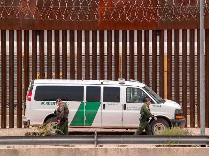 Border patrol van parked by tall metal fence