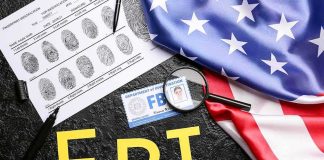 FBI Arrests Woman Accused of Spying for Beijing FBI letters with fingerprint sheet, badge, magnifying glass, and US flag