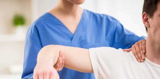 Physical therapist guiding a patient's arm during shoulder exercise