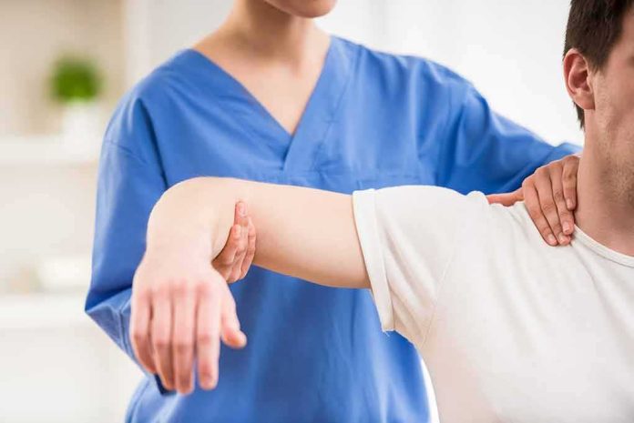 Physical therapist guiding a patient's arm during shoulder exercise