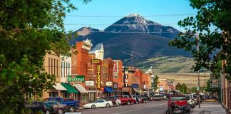 small town main street with parked cars and mountain backdrop