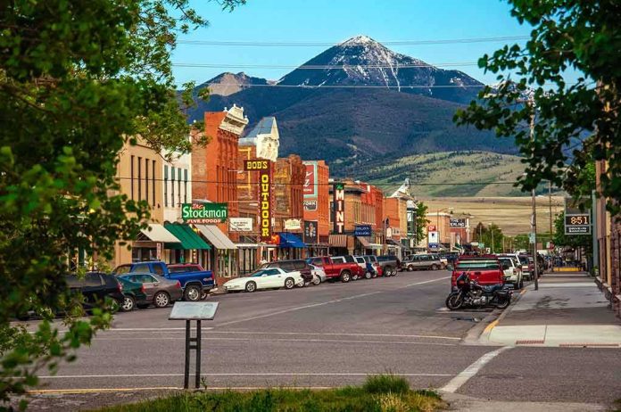 small town main street with parked cars and mountain backdrop